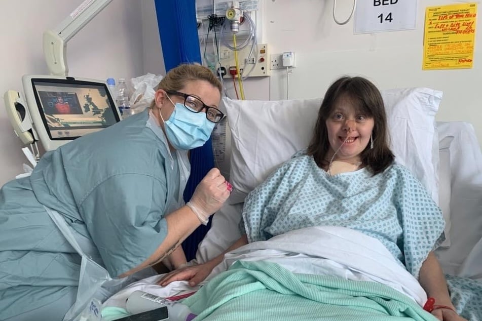 Clare Wakeford smiles at the camera with a nurse.