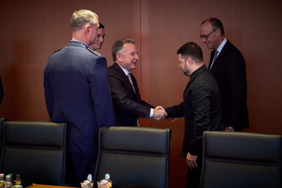 Ukraine's President Volodymyr Zelensky shakes hands with US Special Envoy to the Middle East Steve Witkoff next to US President Donald Trump's son-in-law Jared Kushner, German Chancellor Friedrich Merz, and NATO Supreme Allied Commander Europe, US Air Force General Alexus Grynkewich, in Berlin, Germany, December 14, 2025.