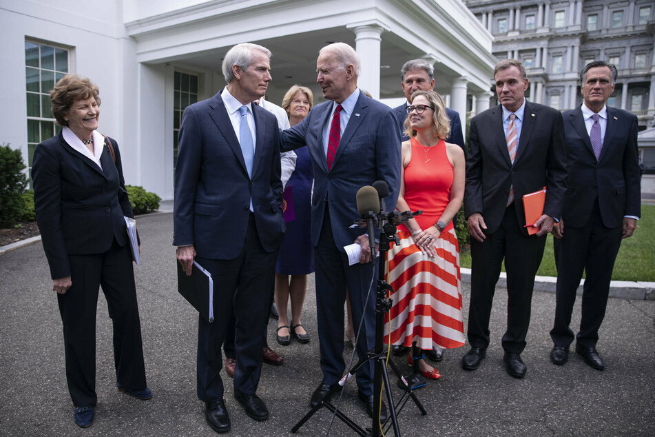 Joe Biden places his arm around Republican Senator Rob Portman of Ohio.