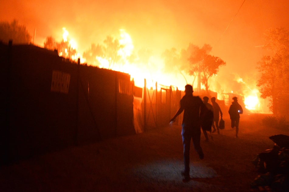 Geflüchtete rennen während das Feuer im Flüchtlingslager Moria auf der Insel Lesbos brennt.