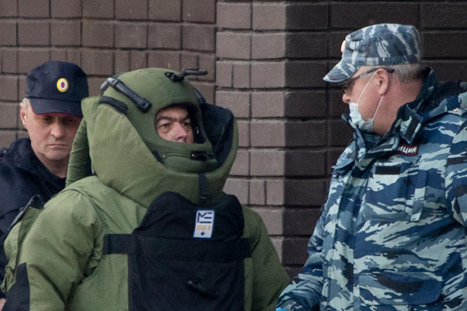Polizeibeamte und Mitglieder der Russischen Nationalgarde, Rosgvardia, verlassen eine Filiale der Alfa-Bank.
