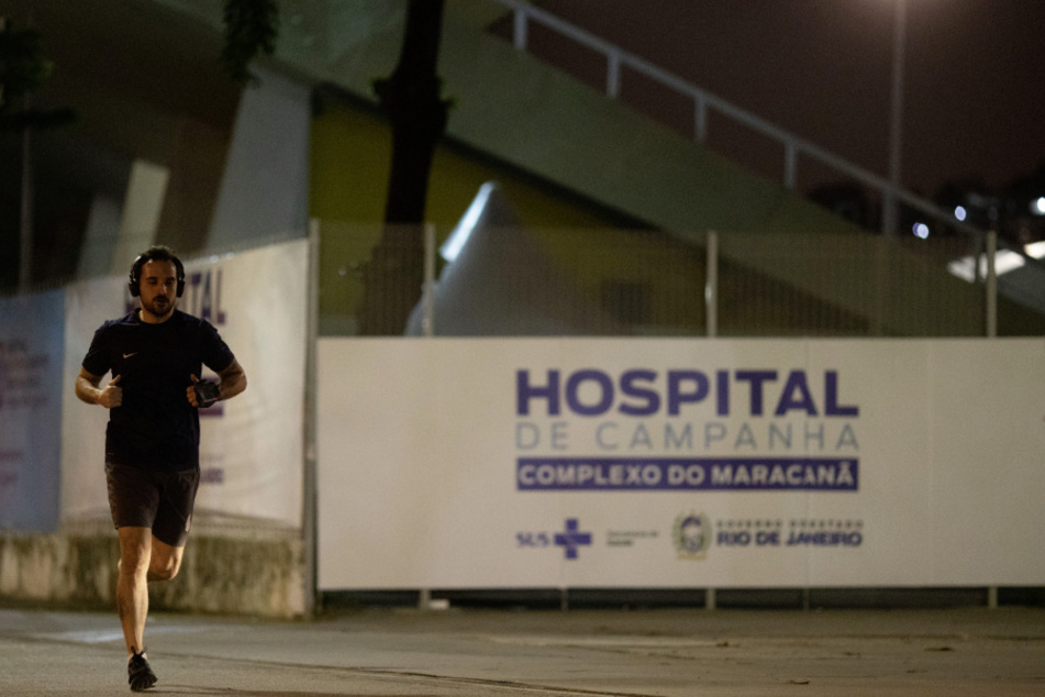Rio De Janeiro: Ein Mann läuft an einem Schriftzug vorbei "Hospital de Campanha Complexo Do Maracana", vor dem Maracanã-Stadion, in dessen Anbau sich das Feldlazarett zur Behandlung von COVID19-Patienten befindet.