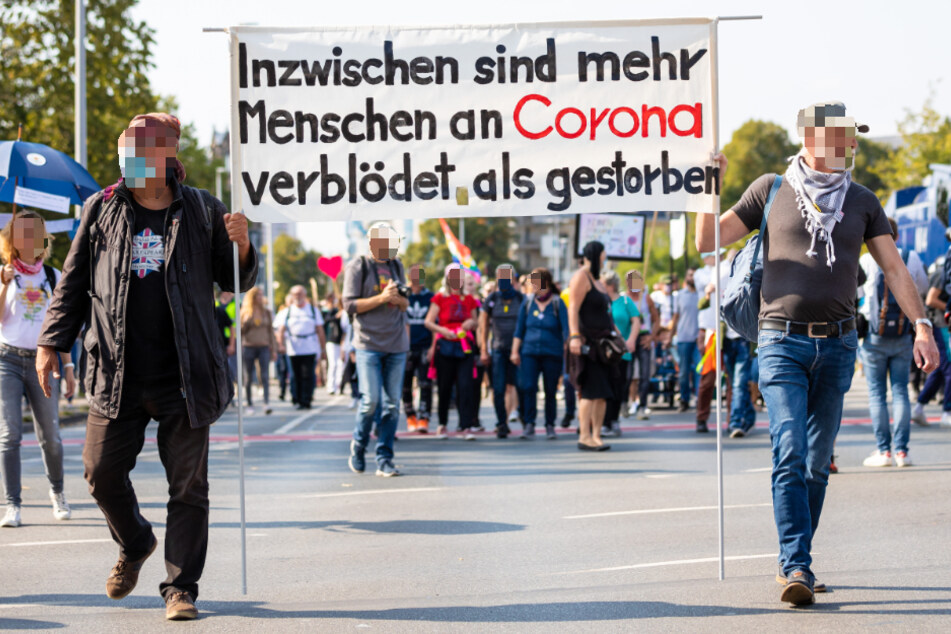 "Inzwischen sind mehr Menschen an Corona verblödet als gestorben" ist auf einem Plakat der Demonstranten zu lesen.