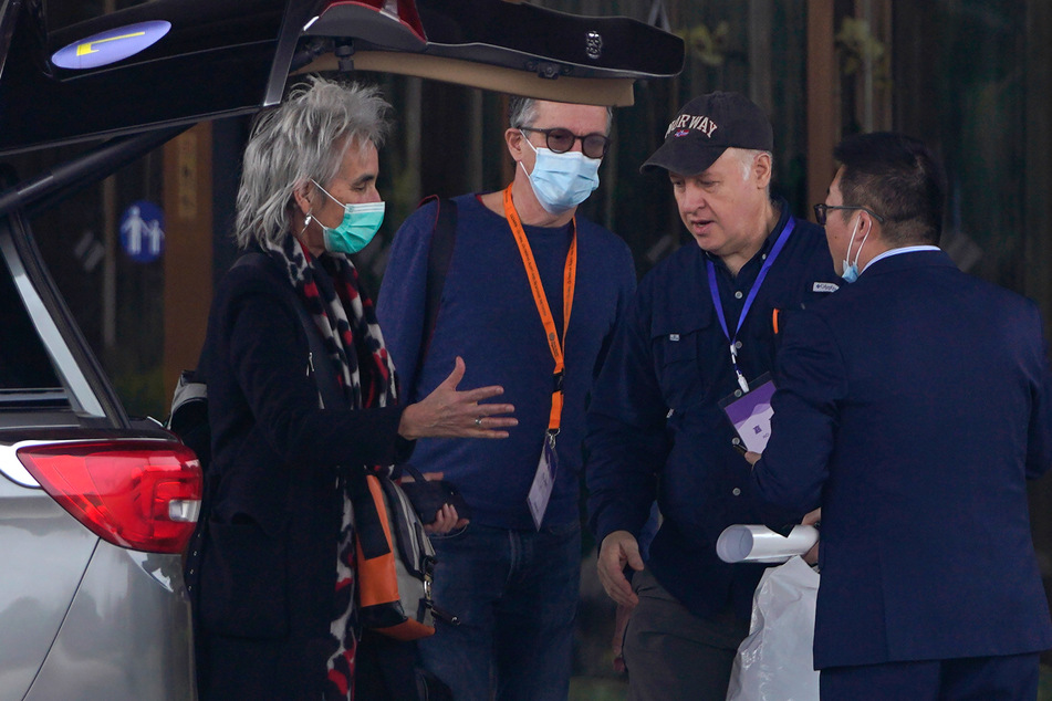 Mitglieder des Expertenteams der Weltgesundheitsorganisation (WHO) stehen vor ihrem Hotel.