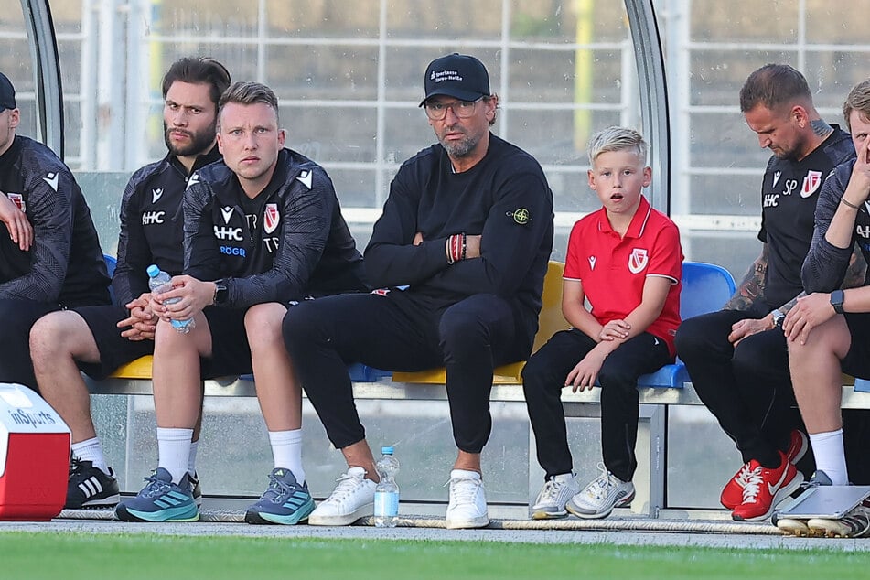Pele Wollitz (60, mit Cap) und Assistant Tobias Röder (28, links daneben) müssen zig Personalentscheidungen moderieren.