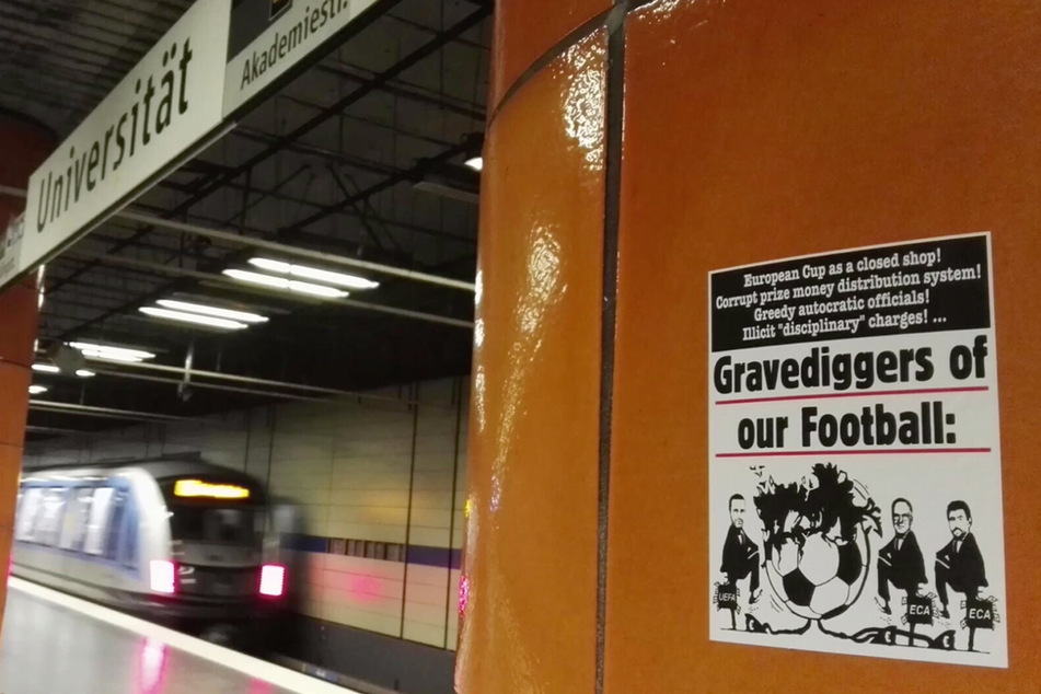 Das Video zeigt mehrere Plätze in München, auf denen Aufkleber mit UEFA-kritischen Texten zu finden sind.