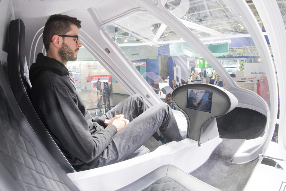 Ein Mann sitzt am Stand von Intel bei der Digitalisierungsmesse Cebit in Hannover im Volocopter-Cockpit. Bislang ist auf Flügen aus Sicherheitsgründen immer ein Pilot mit dabei. (Archivbild)