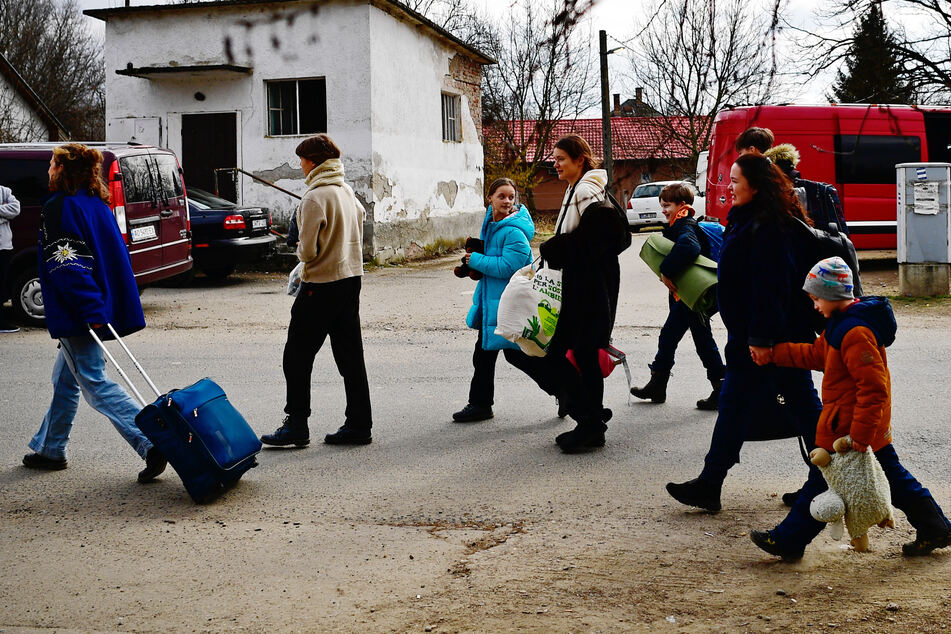 Menschen, die vor dem Krieg und dem russischen Angriff aus der Ukraine geflüchtet sind, kommen an der Grenze zur Ukraine in der ungarischen Gemeinde Tiszabecs an.