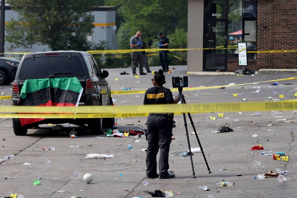 Police investigate the scene where approximately 16 people were shot, one fatally, in a parking lot outside BCD Liquors in Willowbrook, Illinois, in the early hours of June 18, 2023.