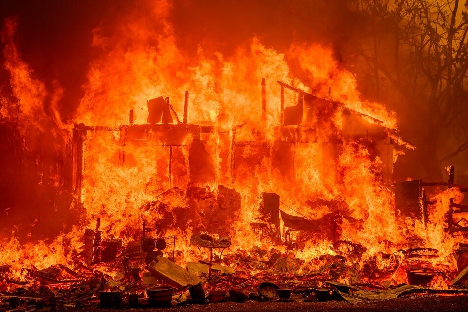 Flames engulf a home during the Thompson Fire in Oroville, California.