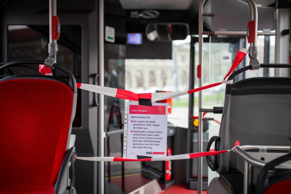 Der Zugang zum Fahrerbereich in einem Linienbus ist zum Schutz des Fahrers wegen des Coronavirus für die Fahrgäste mit einem Absperrband und einem Hinweiszettel blockiert.