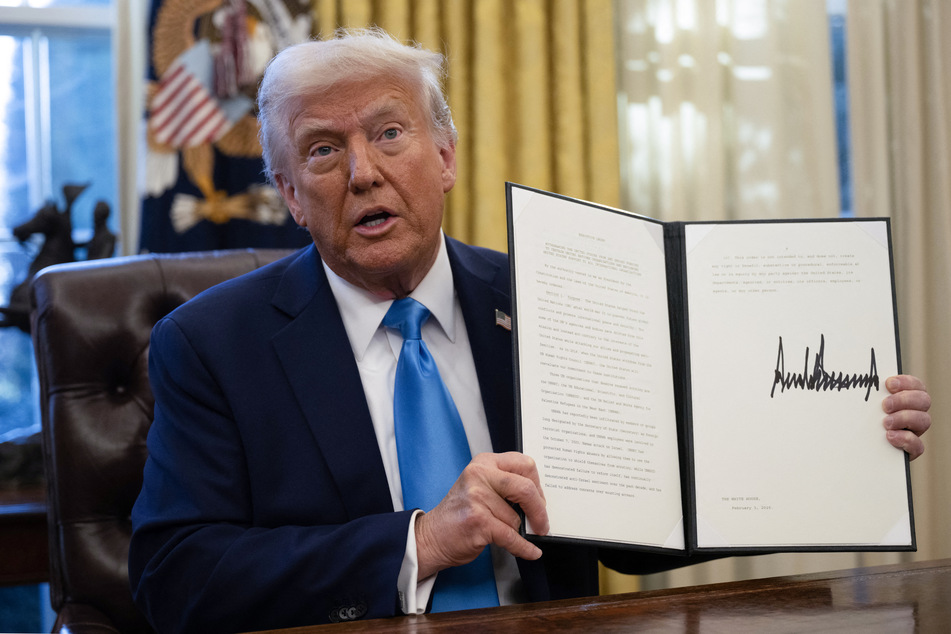 President Donald Trump shows an executive order withdrawing his country from a number of United Nations bodies in the Oval Office of the White House on Tuesdat in Washington, DC.