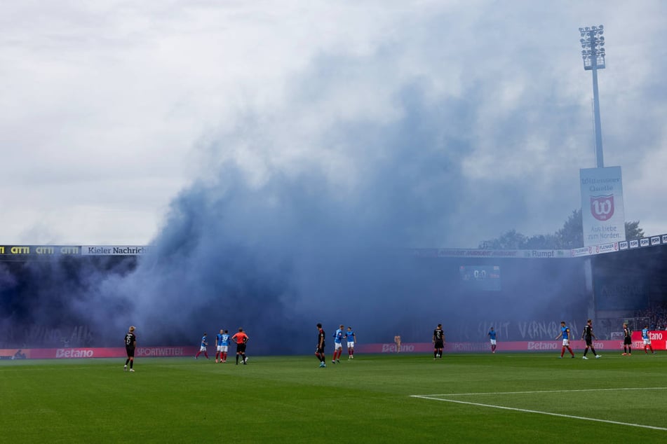 Eine dichte Rauchwolke wabert aus dem Block der Kieler Fans und sorgt gleich zu Beginn der Partie für eine kurze Unterbrechung.