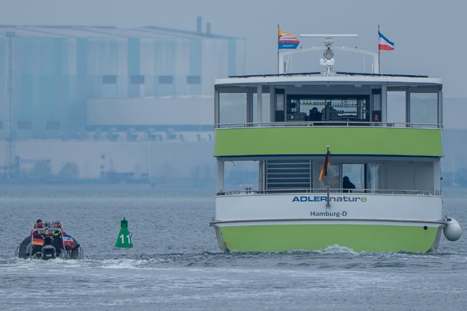 Die Fähre, die zwischen Wismar und Poel unterwegs ist, wird nun von einem Boot der Wasserschutzpolizei (l.) begleitet und überwacht.