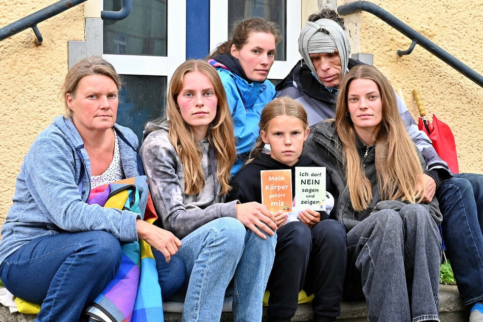 Sitzen nun wortwörtlich auf der Straße: Mama Annette Rednik mit den Töchtern Michelle (25), Jenny (27), Zarina (10) und Anna (24). Daneben der am Kopf verletzte Familienvater Michael (57).