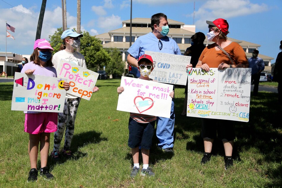 A Florida family protests in favor of masks at public schools outside the Pinellas County School Board.