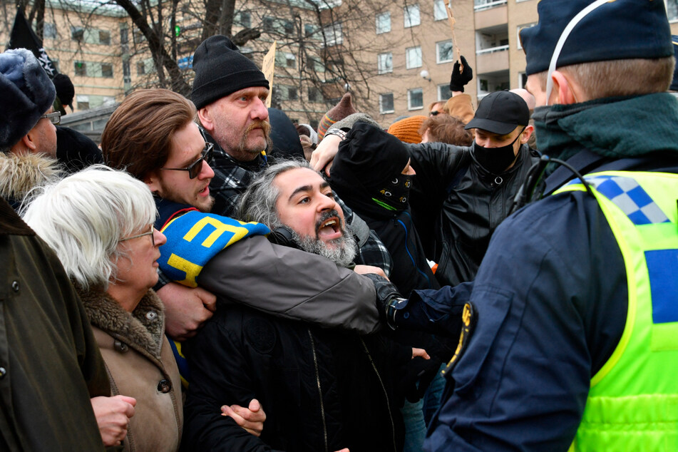Menschen demonstrieren in Schweden ohne Mund-Nasen-Schutz gegen die Corona-Beschränkungen des Landes und treffen auf Polizisten.