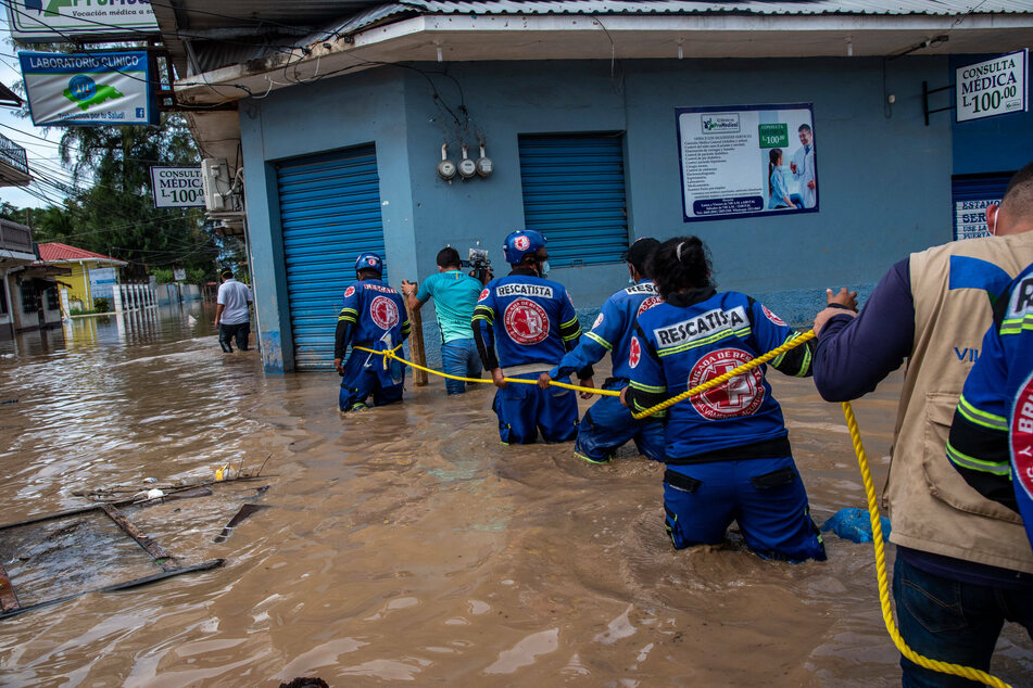 An El Salvadorian rescue team navigates through a flooded street.