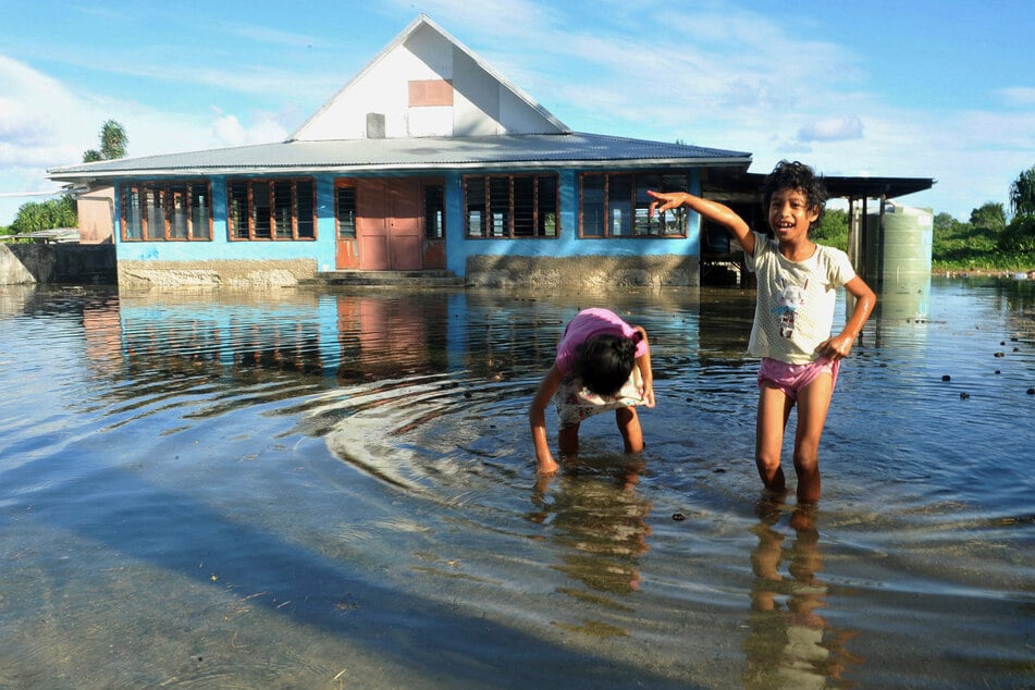 Kinder spielen im Januar 2014 auf einem vom Meerwasser überfluteten Platz in Funafuti.