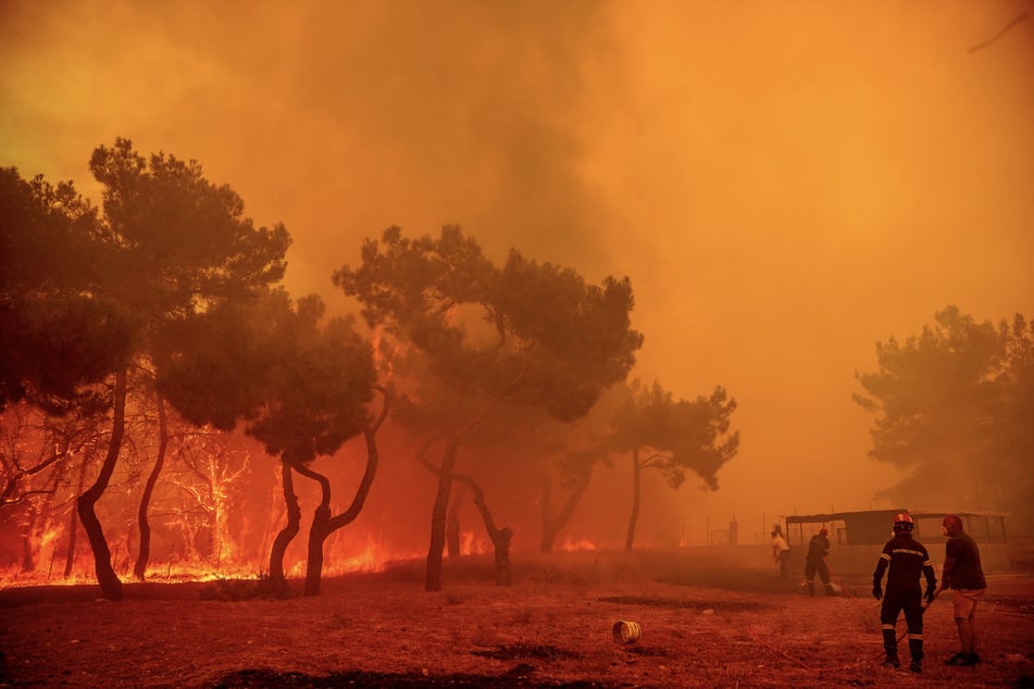 Feuerwehrleute und Freiwillige kämpfen im Juli 2022 gegen die Waldbrände auf der Ferieninsel Lesbos an.
