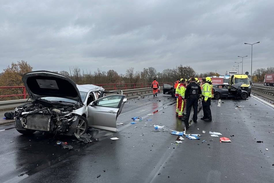 Einsatzkräfte auf der Fahrbahn in Richtung Bautzen stehen in den Trümmern.