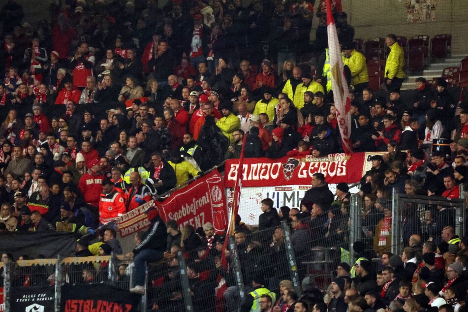 Sanitäter kümmern sich im Gästeblock von Mainz 05 um einen kollabierten Fan.