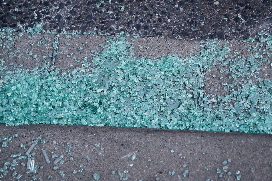 Glasscherben einer Autoscheibe liegen auf einem Gehweg. Sie stammen nach einer Zeugenaussage von einem Auto, in dem zwei Männer von einem MEK der Polizei festgenommen wurden.