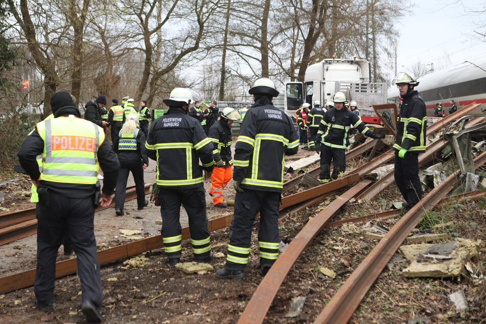 Die Feuerwehr ist mit zahlreichen Einsatzkräften vor Ort, um sich um die Verletzten und die Bergung des Sattelzuges zu kümmern.