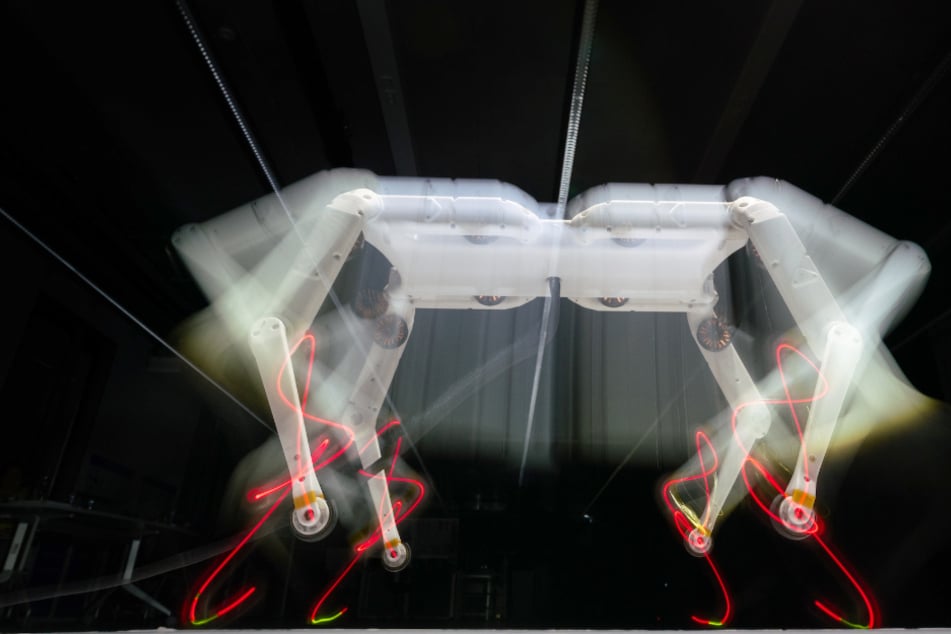 Ein vierbeiniger Roboter springt auf einer Platte (Wischeffekt durch Langzeitbelichtung).