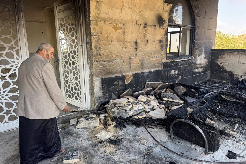 Fire damage is seen at the entrance of Al-Rahmah Mosque following an arson attack by Israeli settlers in the village of Qusra on July 26, 2026.