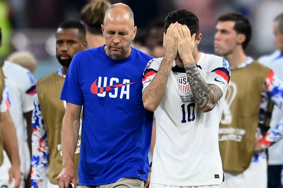 USMNT head coach Greg Berhalter and forward Christian Pulisic walk off the pitch after their loss to the Netherlands.