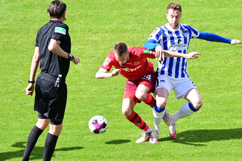 Schiedsrichter Deniz Aytekin (l.) hat beim Zweikampf zwischen Herthas Lukas Klünter (r.) und Kölns Dominik Drexler (M.) alles im Blick.