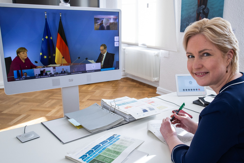 Manuela Schwesig (SPD), die Ministerpräsidentin von Mecklenburg-Vorpommern, sitzt in der Staatskanzlei bei der Video-Schaltkonferenz zur Entwicklung der Corona-Pandemie vor einem Monitor, auf dem Bundeskanzlerin Angela Merkel (CDU) und Michael Müller (SPD), der Regierende Bürgermeister von Berlin, zu sehen sind.