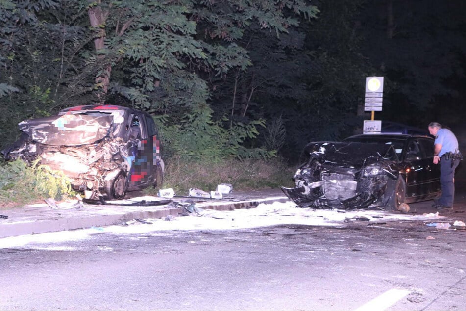 Ein Polizist untersucht das Wrack des Audi. Links im Bild ist der völlig zerstörte Wagen des Pizza-Lieferanten zu sehen.