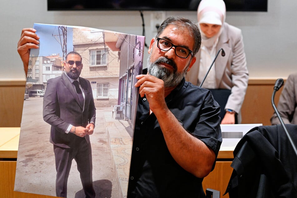 Erdal Calar, der Vater des getöteten Zugbegleiters Serkan Calar, hält im Verhandlungssaal ein Bild des Opfers in den Händen. Die Familie trat bei dem Prozess als Nebenkläger auf.
