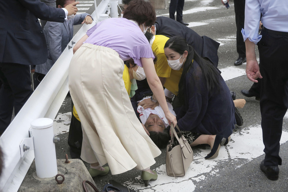 Japans ehemaliger Premierminister Shinzo Abe (67) liegt nach dem Anschlag am Boden und wird medizinisch versorgt.