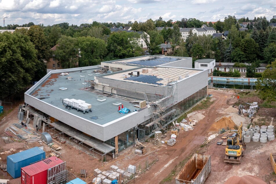 Die äußere Hülle der neuen Schwimmhalle ist fertiggestellt. Auf dem Dach werden Solarmodule installiert.