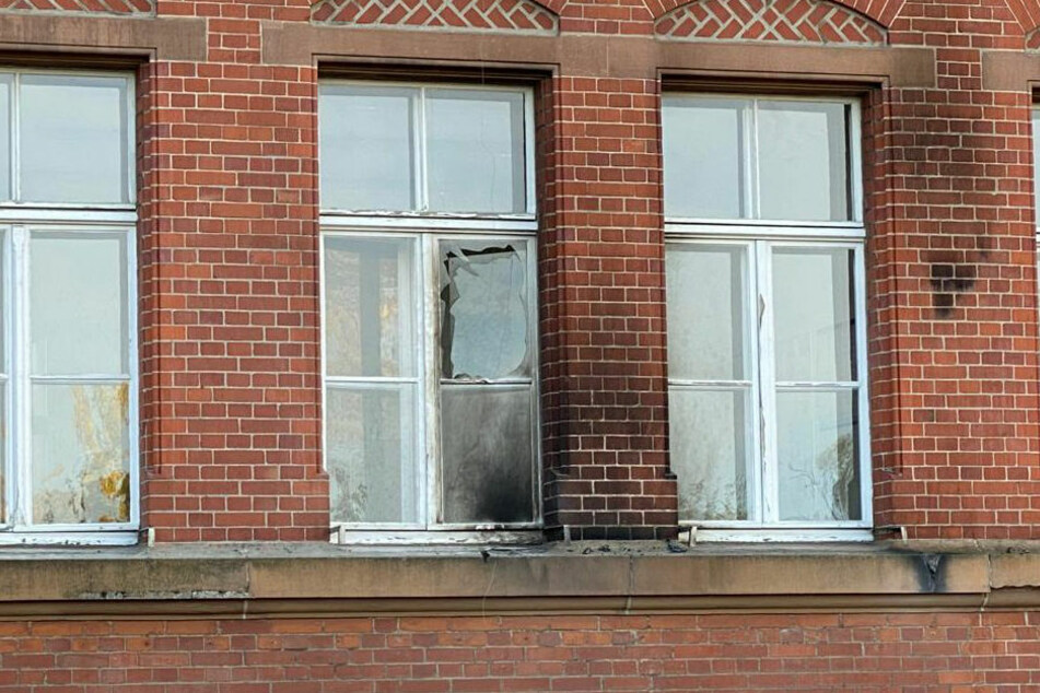 An der Fassade des Gebäudes sind die Brandspuren zu erkennen, ebenso die zerstörte Fensterscheibe.