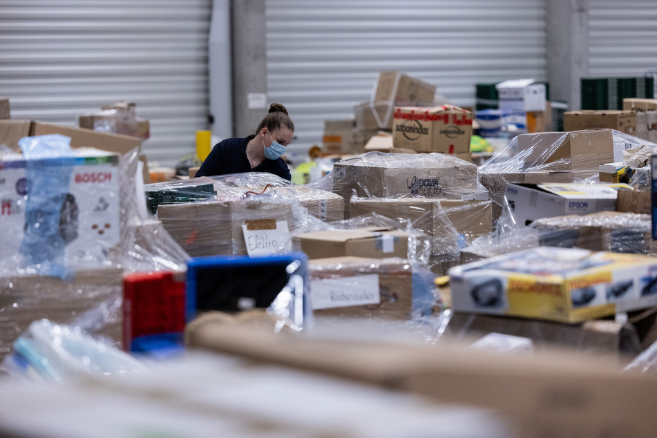 Eine freiwillige Helferin sortiert in einem Logistik-Lager des Deutschen Rotes Kreuz (DRK) Sachspenden für die Opfer der Hochwasserkatastrophe.