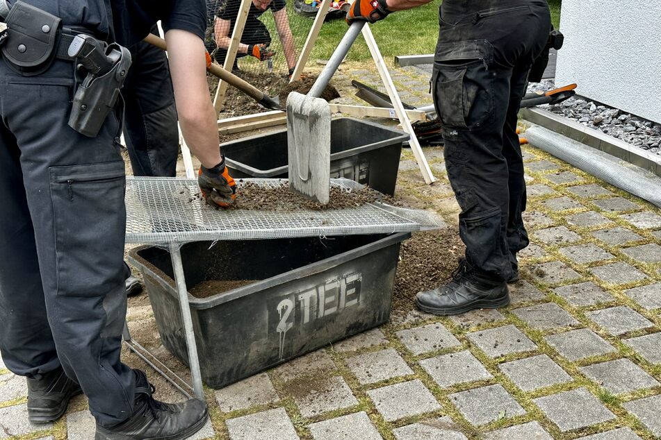 Polizisten suchen in einem Solinger Garten nach Knochenteilen und Beweismaterialien.