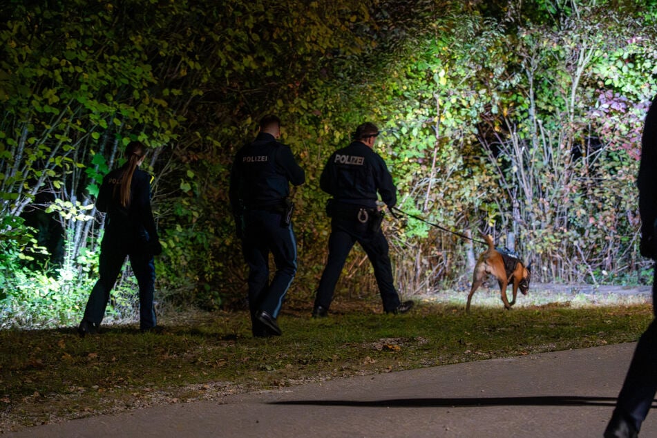 Mit Polizeihunden suchen Einsatzkräfte nach dem flüchtigen zweiten Täter.