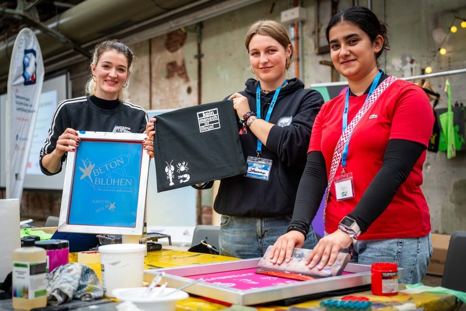 Zeynep (17, r.) und Johanna (18, M.) haben mit Nele (30, l.) vom Projekt im:puls selbst Jutebeutel bedruckt.