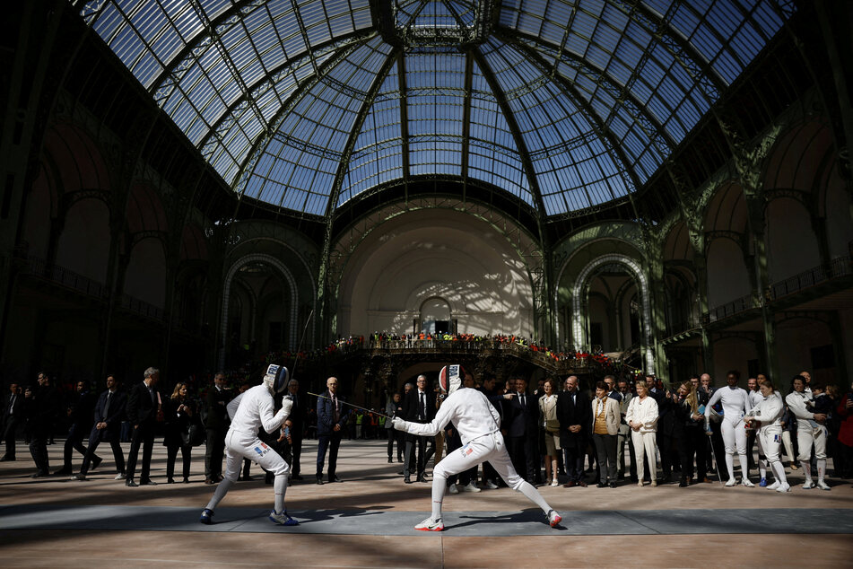 French President Emmanuel Macron attends a demonstration by the French fencing team during his visit to the Grand Palais ahead of the Paris Olympics.