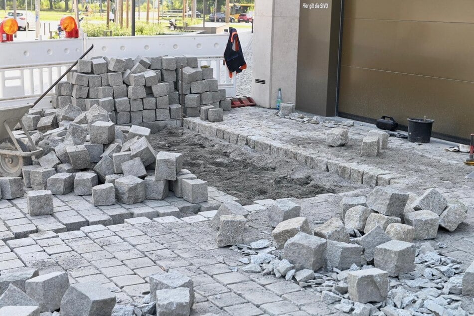 Arbeiter kümmern sich um die Neuverlegung der Pflastersteine.