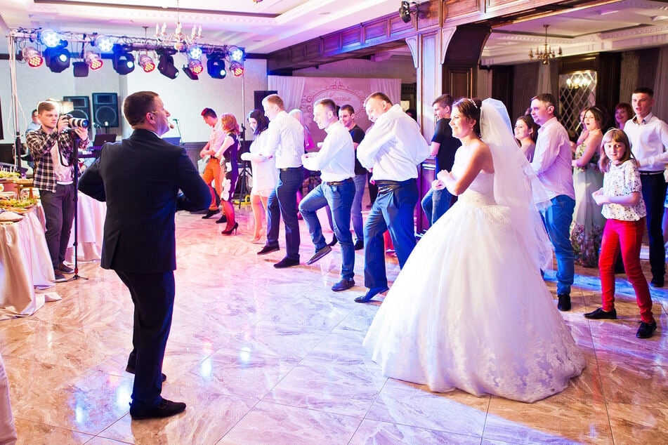 Participants of a wedding ceremony dance around the bridal couple (symbolic picture).