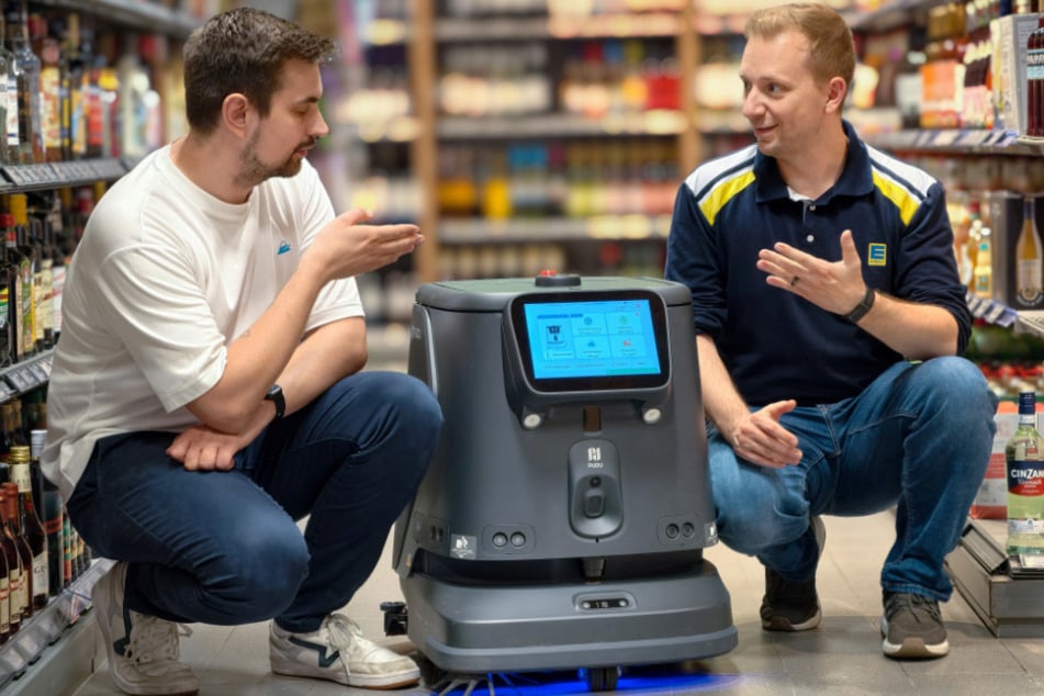 Marktleiter Philipp König (39, r.) und Marty Friedrich (32) von der TU Chemnitz fachsimpeln über Funktionen des Putz-Roboters.