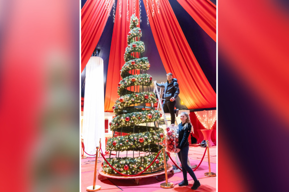 Miguel Hein (23) und Michelle Putnins (23) schmücken den großen Weihnachtsbaum im Vorzelt.