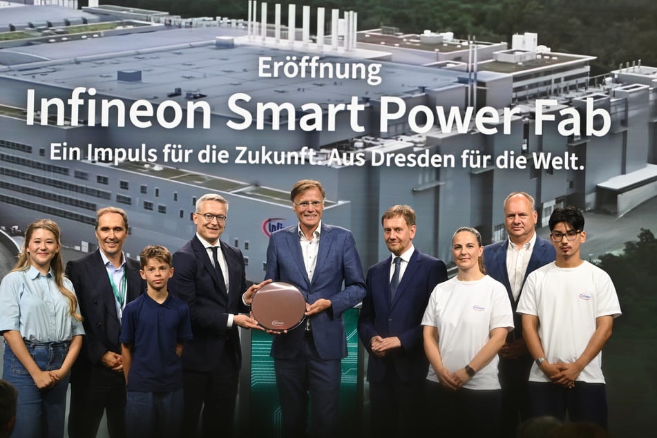 Zusammen mit Auszubildenden freuen sich Jochen Hanebeck, Vorstandsvorsitzender von Infineon (Mitte rechts), Karsten Wildberger (CDU, Mitte links), Bundesminister für Digitalisierung und Staatsmodernisierung, Michael Kretschmer (CDU, 4.v.r.), Ministerpräsident von Sachsen, und OB Dirk Hilbert (FDP, 2.v.r.) über die Eröffnung.