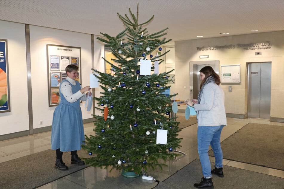 Anika Gränz, Referentin für barrierefreies Lernen (l.), und Stefanie Elies, pädagogische Mitarbeiterin VHS ALFA, schmückten den VHS-Weihnachtswunschbaum mit den Herzenswünschen der Teilnehmenden.