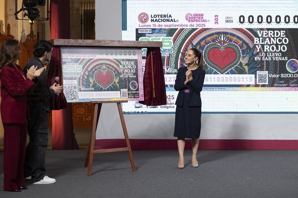 This handout picture released by Mexican presidency press office shows Mexico's President Claudia Sheinbaum (r.) showing an image of a lottery ticket during her daily press conference at the National Palace in Mexico City on Friday.